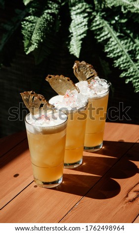 cold refreshing cocktail on a wood on a summer sunny day with friends