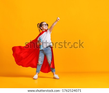 Full body girl in superhero cape smiling and raising fist up while being ready for school studies against yellow backdrop
 Royalty-Free Stock Photo #1762524071