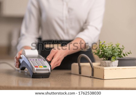 The waiter accepts payment through the terminal, contactless payment, business