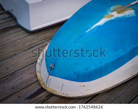 Abstract shapes and texture of upside down bottom of a blue boat with white trim