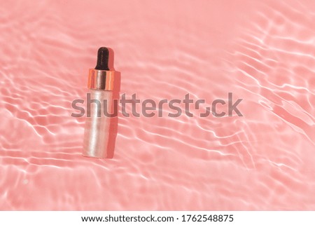pink liquid highlighter in pink water with waves and sun glare with copy space