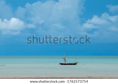 one wooden boat on the coast of a wide in sunny day,Lonely wooden old boat on the lake,Beautiful Landscape summer vertical front viewpoint tropical sea beach white sand clean and blue sky background 