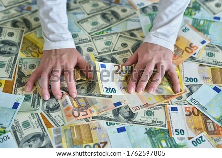 female hands reach for a heap of money. dollar and euro banknotes on the table. The concept of wealth, success, greed and corruption, lust for money Royalty-Free Stock Photo #1762597805