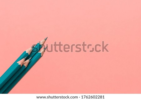 Template with copy space by top view close up macro photo of wooden pencils isolated on pink paper that look minimalist and clean.