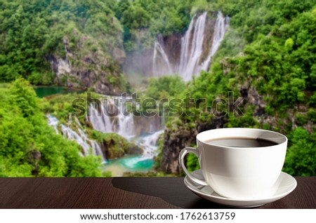 Cup of black coffee or tea with big waterfall background in Croatia