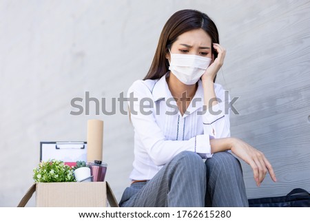Asian woman is laid off due to COVID-19 and feel upset with faicial mask Royalty-Free Stock Photo #1762615280