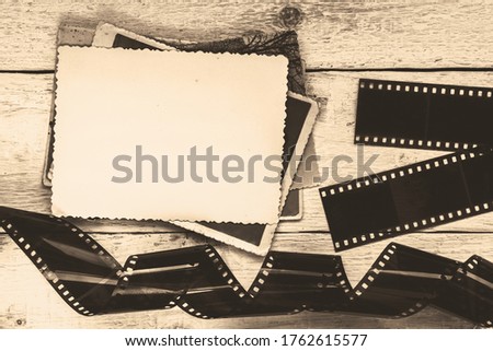 Old photos and film on a wooden background. Empty photo frame.