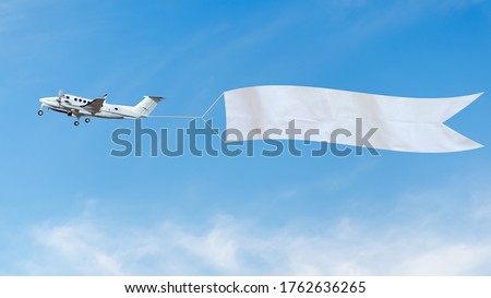 Plane flies in the sky with a white banner for ad. 