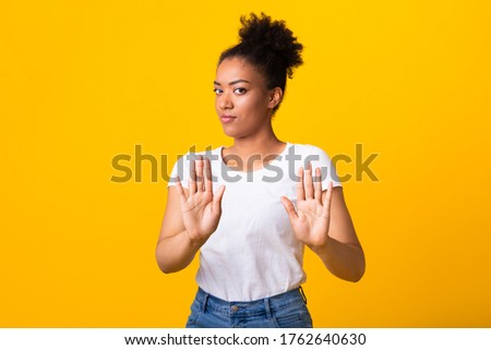 Say No To Racism. Serious african american woman making stop hand gesture isolated over yellow studio wall Royalty-Free Stock Photo #1762640630