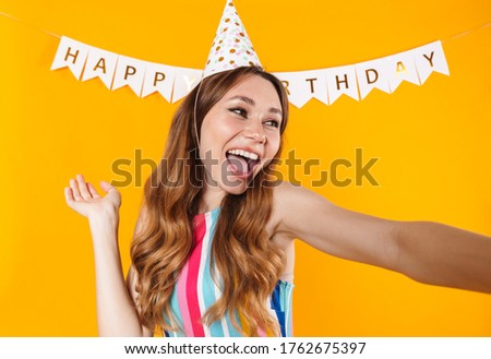 Image of joyful cute woman taking selfie photo and laughing isolated over yellow background