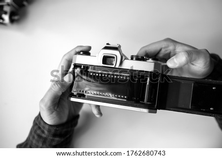 Male hands reloading film retro camera on a white table. Horizontal. top view
