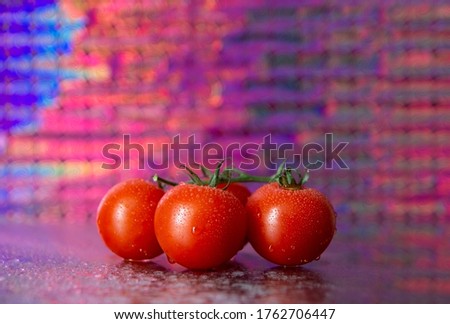 cherry tomatoes on a colored background with reflection in glass