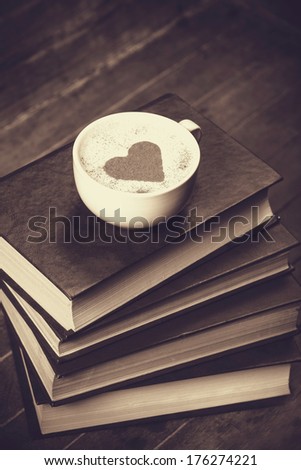 Cup of coffee with books. Photo in old color image style.