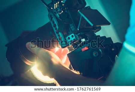 Professional Digital SLR Camera Operator with Equipment in His Hands. Videography and Motion Picture Production Equipment. 