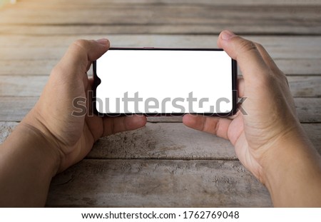 Play games on smartphones Close Up view Mobile phone with separate screen Horizontal position, wooden table background.