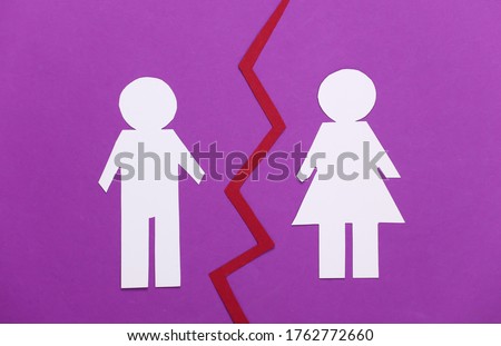 The end of the relationship, divorce. Split paper man and woman on purple background