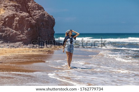 Beautiful woman walking on a sea beach and enjoing with sunny summer day