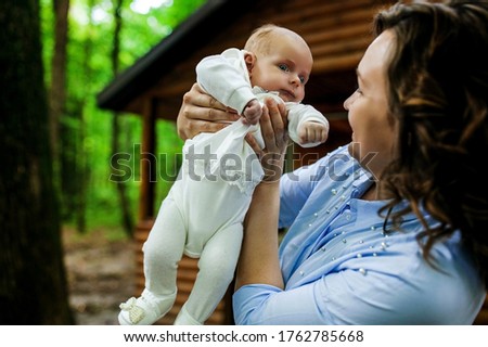 Mother And Newborn Baby with big blue eyes Family Portrait, Mom Embracing New Born Kid