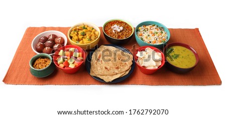 Indian whole meal with yellow dal, vegetable pulao, chapati,gulab jamun, salad, papad, pickle, chana masala curry and aloo gobi Royalty-Free Stock Photo #1762792070