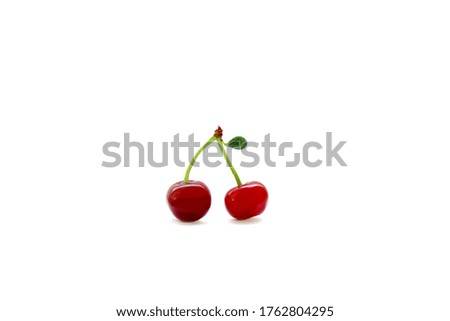 Isolated color photo of two cherries on one branch with a small green leaf on a white background. Summer ripe berries.