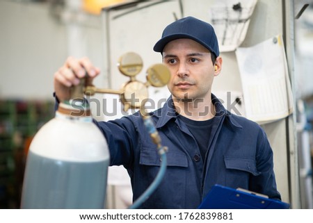 Inspector checking a gas tank in an industrial factory