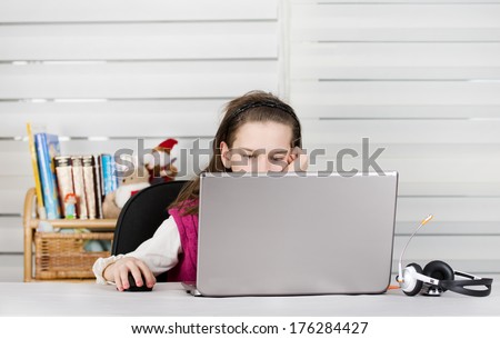 School girl is bored in front of laptop