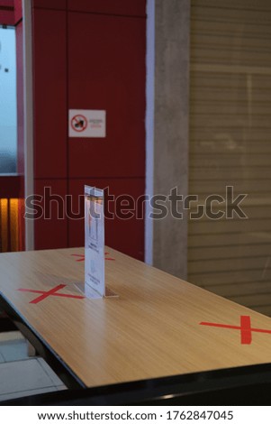 Cross sign stickers mark on table in food court, symbol not allow sitting and close each other. Social distancing rules, policy for re-open restaurant in pandemic crisis to avoid Covid-19 spread