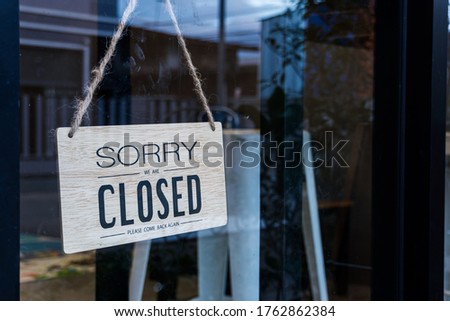 Text on wooden sign "Sorry we're closed " in cafe and restaurant.