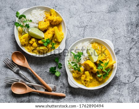 Indian food - vegetarian cauliflower curry with rice, cilantro, lime on grey background, top view             Royalty-Free Stock Photo #1762890494