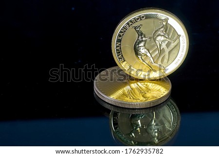 Australian Kangaroo gold coin built on 1 ounce gold coin American Eagle. Gold, mirroring and table.