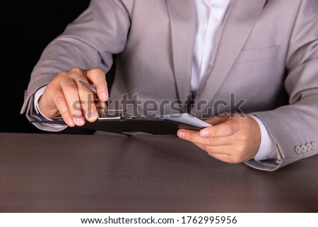 Concept, guy is studying a loan agreement. Concept, thinks how to cut costs. A businessman is studying the conditions of a contract.