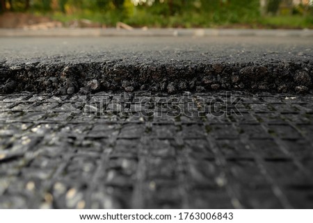 Close-up asphalt at the road under construction. A layer of hot fresh asphalt.