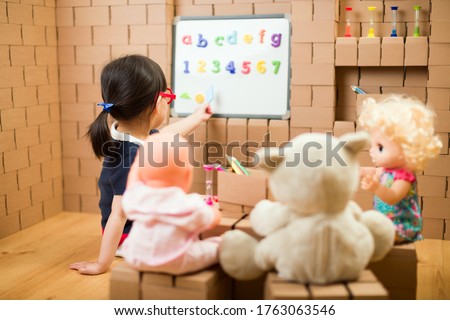 toddler girl pretend play as a teacher at home Royalty-Free Stock Photo #1763063546