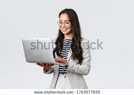Business, finance and employment, female successful entrepreneurs concept. Professional stylish asian businesswoman fixing project on her way to office, using laptop standing whtie background