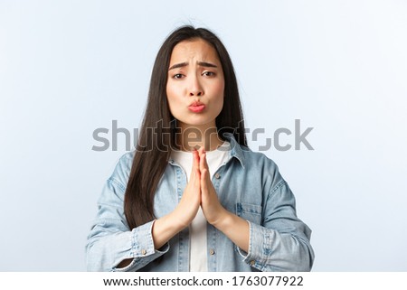 Lifestyle, people emotions and beauty concept. Silly and cute pleading asian girl begging for favour or apology, grimacing looking sad eyes, hold hands in pray as need help, white background Royalty-Free Stock Photo #1763077922