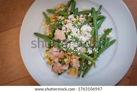 Homemade rustic grilled chicken, green string bean, shallot, farro, and feta cheese. Great summer food dish.