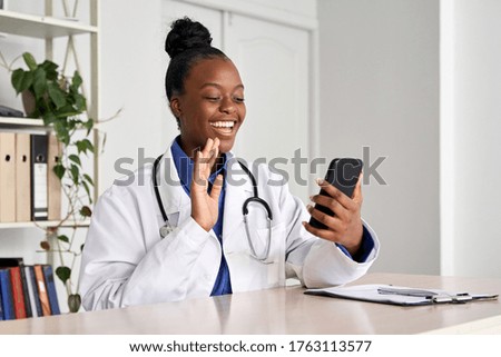 African female doctor holding phone talk to patient make telemedicine online video call. Afro american therapist remote consultation in telemedicine virtual mobile chat application. Telehealth concept Royalty-Free Stock Photo #1763113577