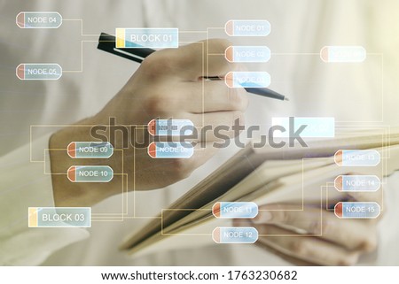 Multi exposure of abstract programming language hologram with man hand writing in notepad on background, artificial intelligence and machine learning concept