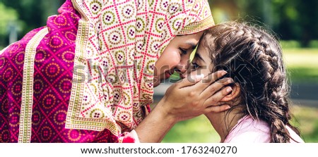Portrait of religious enjoy happy love asian family arabic muslim mother and little muslim girls child with hijab dress smiling and having fun touching face with cute kid daughter moments good time