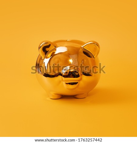 Golden piggy bank on yellow background. Money saving, money box, finance and investments concept.