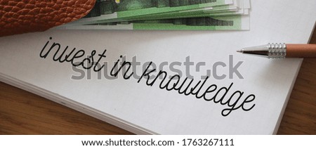 Invest in Knowledge phrase words on Copybook page and 100 Euro banknotes. Education, career and business concept..