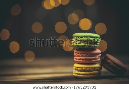 Tasty macaroon cookies with coffee on a wooden table in warm color with beautiful bokeh