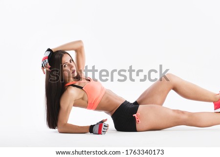 Athletic woman sitting on the floor in the studio. Power and motivation.