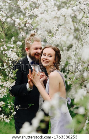 young beautiful couple in the garden against the background of cherry blossoms