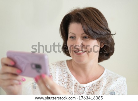Portrait of a woman with a smile looking at a cellphone