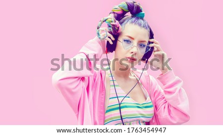 Portrait of cool teenage girl with trendy hairstyle listening music on big headphones – Young fashion woman having fun with technology trends – Stylish gen z teen with crazy hair enjoy modern life Royalty-Free Stock Photo #1763454947