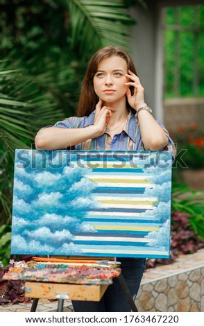 Portrait of a beautiful girl near the easel