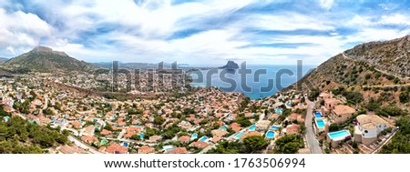 Aerial photography panoramic image Calpe or Calp townscape rooftops picturesque view to bright Mediterranean Sea waters and Parque natural Penon de Ifach or Penyal de Ifac rock, Costa Blanca, Spain