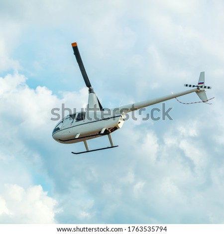 Russian white helicopter flies in the clouds