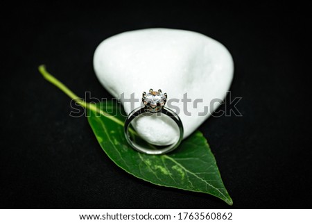 A ring with a diamond on a black background.